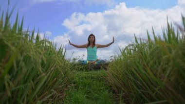 Muladhara çakrası için meditasyon yapan genç bir kadının Bali usulü çekilmiş bir fotoğrafı.
