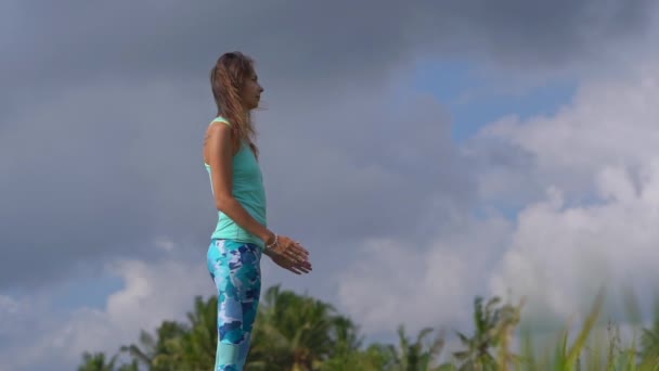 Plan au ralenti d'une jeune femme pratiquant le yoga sur un beau champ de riz — Video