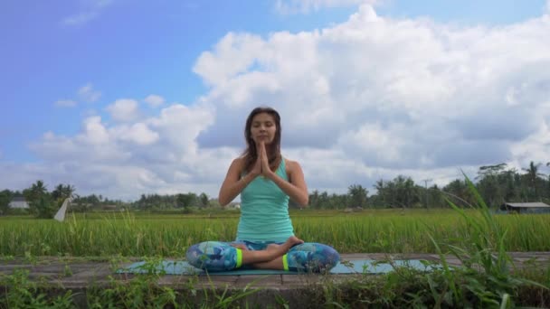 Steadicam lövés egy fiatal nő csinál meditáció Muladhara csakra egy balinéz módon — Stock videók