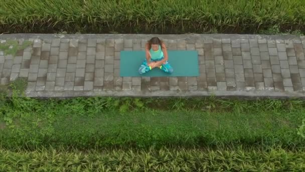 Letecký snímek mladé ženy, jak medituje pro muladharskou čakru balijským způsobem — Stock video