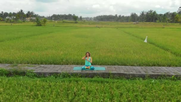 Slowmotion luchtfoto van een jonge vrouw doet meditatie voor Muladhara Chakra in een Balinese manier — Stockvideo