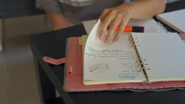 Um tutor de casa ou uma mãe folheando páginas de seu caderno cheias de notas de educação em casa. Conceito de educação familiar. Conceito de ensino em casa — Vídeo de Stock