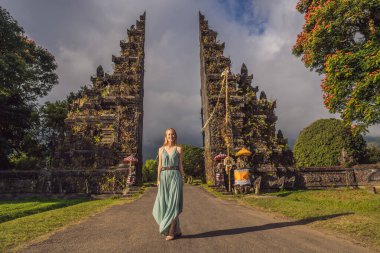 Endonezya 'daki Bratan Gölü Bali Adası yakınlarındaki geleneksel Hindu kapısı Candi Bentar' dan geçen turist kadın. Bali 'de Tatil
