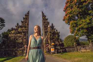 Endonezya 'daki Bratan Gölü Bali Adası yakınlarındaki geleneksel Hindu kapısı Candi Bentar' dan geçen turist kadın. Bali 'de Tatil