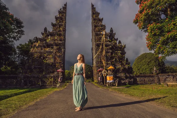 Turista mujer caminando a través de la tradicional puerta hindú balinesa Candi Bentar cerca de Bedugul, Bratan lago Bali isla Indonesia. Vacaciones en Bali —  Fotos de Stock