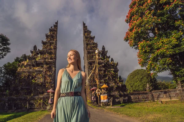 Turista mujer caminando a través de la tradicional puerta hindú balinesa Candi Bentar cerca de Bedugul, Bratan lago Bali isla Indonesia. Vacaciones en Bali — Foto de Stock