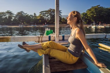 Genç bir kadın gezgin şafakta denizde bir teknede tanışır.