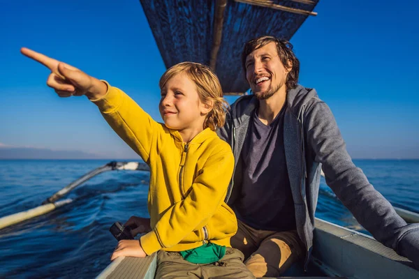 Padre e figlio viaggiatori incontra l'alba nel mare su una barca — Foto Stock
