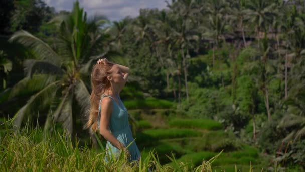 Fotografía en cámara lenta de una hermosa joven con un vestido azul visita las famosas terrazas de arroz de Tegalalang en el pueblo de Ubud en la isla de Bali — Vídeos de Stock