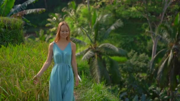 Slowmotion shot of a beautiful young woman in a blue dress visits famous Tegalalang Rice Terraces in Ubud village on the Bali island — ストック動画