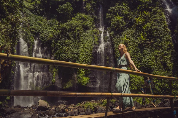 Frau in türkisfarbenem Kleid an den Sekumpul-Wasserfällen im Dschungel auf der Insel Bali, Indonesien. bali Reisekonzept — Stockfoto