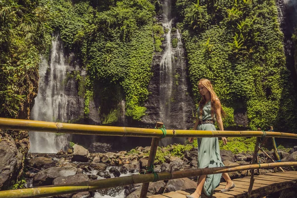 Frau in türkisfarbenem Kleid an den Sekumpul-Wasserfällen im Dschungel auf der Insel Bali, Indonesien. bali Reisekonzept — Stockfoto