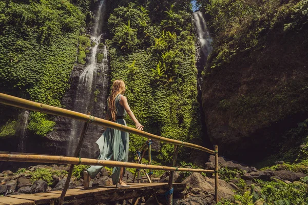 Mulher de vestido turquesa nas cachoeiras Sekumpul em selvas na ilha de Bali, Indonésia. Bali Travel Concept — Fotografia de Stock