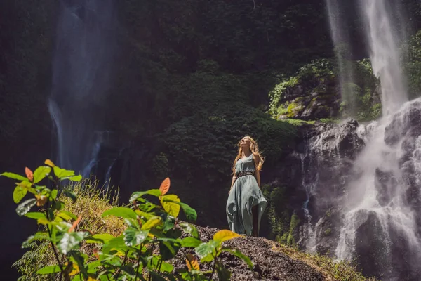 Mulher de vestido turquesa nas cachoeiras Sekumpul em selvas na ilha de Bali, Indonésia. Bali Travel Concept — Fotografia de Stock