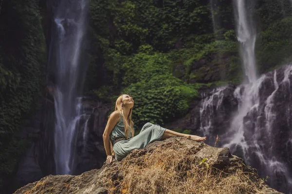 Женщина в бирюзовом платье у водопада Секумпул в джунглях на острове Бали, Индонезия. Путешествие на Бали — стоковое фото