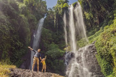 Baba ve oğlu Endonezya 'nın Bali adasındaki Sekumpul şelalelerinde. Bali Seyahat Konsepti