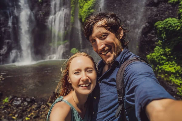 Pareja cariñosa en las cascadas de Sekumpul en las selvas de la isla de Bali, Indonesia. Concepto de viaje de Bali — Foto de Stock