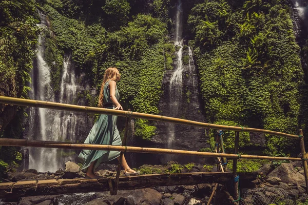 Frau in türkisfarbenem Kleid an den Sekumpul-Wasserfällen im Dschungel auf der Insel Bali, Indonesien. bali Reisekonzept — Stockfoto