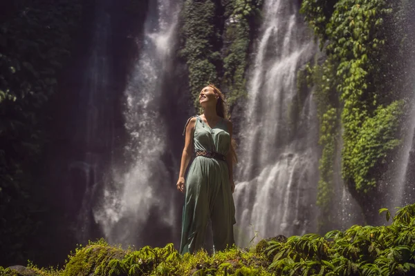 Frau in türkisfarbenem Kleid an den Sekumpul-Wasserfällen im Dschungel auf der Insel Bali, Indonesien. bali Reisekonzept — Stockfoto