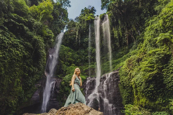 Женщина в бирюзовом платье у водопада Секумпул в джунглях на острове Бали, Индонезия. Путешествие на Бали — стоковое фото