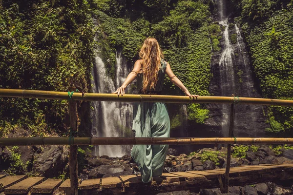 Frau in türkisfarbenem Kleid an den Sekumpul-Wasserfällen im Dschungel auf der Insel Bali, Indonesien. bali Reisekonzept — Stockfoto