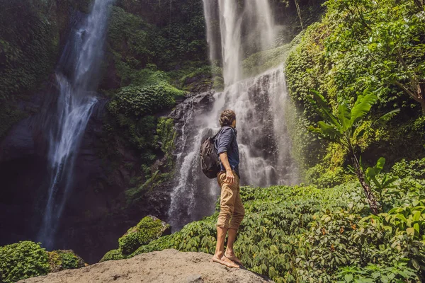 Homem de vestido turquesa nas cachoeiras Sekumpul em selvas na ilha de Bali, Indonésia. Bali Travel Concept — Fotografia de Stock