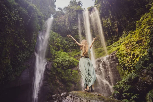 Mulher de vestido turquesa nas cachoeiras Sekumpul em selvas na ilha de Bali, Indonésia. Bali Travel Concept — Fotografia de Stock