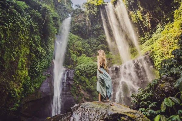 Mulher de vestido turquesa nas cachoeiras Sekumpul em selvas na ilha de Bali, Indonésia. Bali Travel Concept — Fotografia de Stock