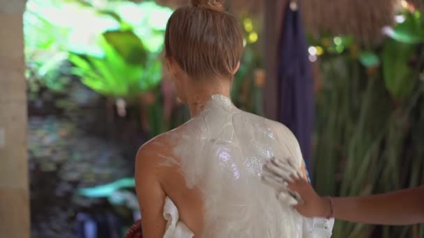 Slowmotion Close-up shot van een jonge vrouw in een tropische spa.beaucian brengt huid moisturizer verbinding op haar huid — Stockvideo