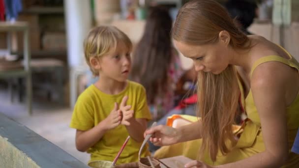 Slowmotion shot of a little boy and his mother on a pottery master class — Stock Video