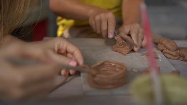 Prise de vue au ralenti d'un petit garçon et de sa mère en classe de maître de poterie — Video