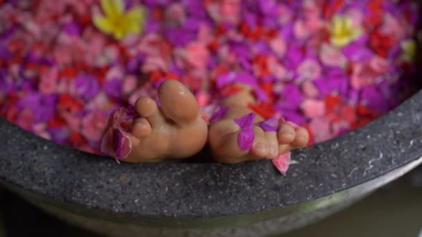 Slowmotion tiro de uma bela jovem que toma um banho floral em um spa tropical — Vídeo de Stock