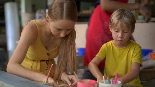 Scatto al rallentatore di un bambino e sua madre su una classe master di ceramica — Video Stock