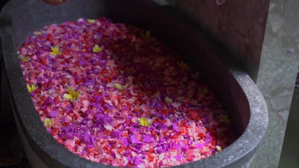 Langzame opname van een dienstverlener die een bloembad bereidt in een tropische spa — Stockvideo