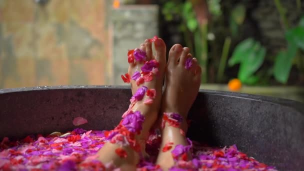 Fotografía en cámara lenta de una hermosa joven tomando un baño floral en un spa tropical — Vídeos de Stock