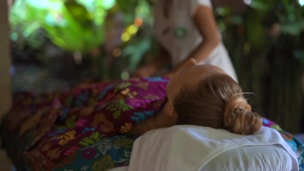 Zeitlupe Nahaufnahme einer jungen Frau in einem tropischen Spa. Kosmetikerin trägt Körperpeeling auf — Stockvideo