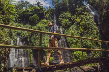 Endonezya 'nın Bali adasındaki Sekumpul şelalelerinde turkuaz elbiseli bir adam. Bali Seyahat Konsepti