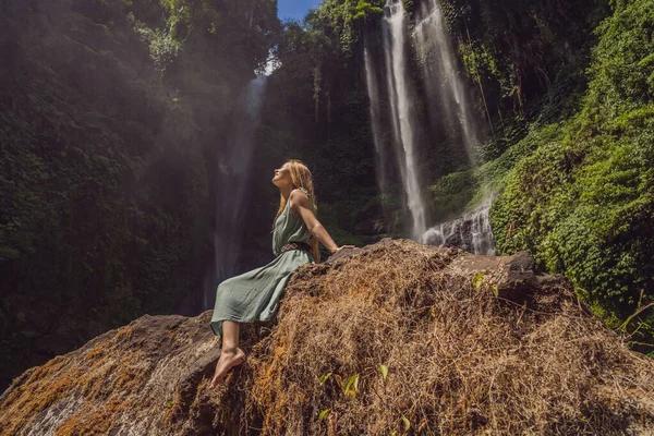 Mulher de vestido turquesa nas cachoeiras Sekumpul em selvas na ilha de Bali, Indonésia. Bali Travel Concept — Fotografia de Stock
