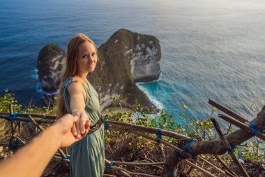 Aile tatili yaşam tarzı. Mutlu kadın bakış açısında duruyor. Yüksek uçurumun altındaki güzel sahile bak. Bali 'ye seyahat. Nusa Penida adasında ziyaret etmek için popüler bir yer.