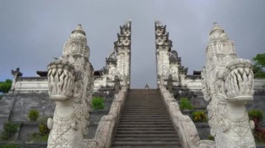 Karangasem, Doğu Bali, Endonezya 'daki Besakih Tapınağı' nda merdivenleri koruyan taş ejderhaların el kamerası görüntüsü.