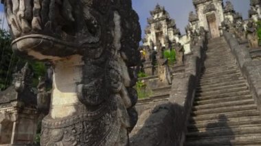 Karangasem, Doğu Bali, Endonezya 'daki Besakih Tapınağı' nda merdivenleri koruyan taş ejderhaların el kamerası görüntüsü.