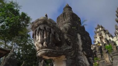 Karangasem, Doğu Bali, Endonezya 'daki Besakih Tapınağı' nda merdivenleri koruyan taş ejderhaların el kamerası görüntüsü.