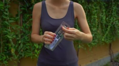 Birisi veri kablosu olan bir kutuyu açıyor ve ne kadar plastiğin çöpe atılacağını gösteriyor. Fazla plastik ambalaj kavramı. Plastik atık kavramını küçült