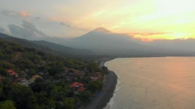 Amed bölgesindeki güzel Jemeluk Koyu 'nun muhteşem Agung volkanı manzaralı havadan çekimi. Amed 'de günbatımı. Bali konseptine Seyahat