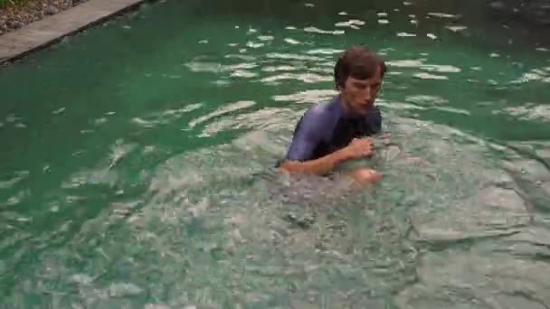 A fiatalember egy medencében edzi a harci technikáját. Harci képzés a medence koncepciójában — Stock videók