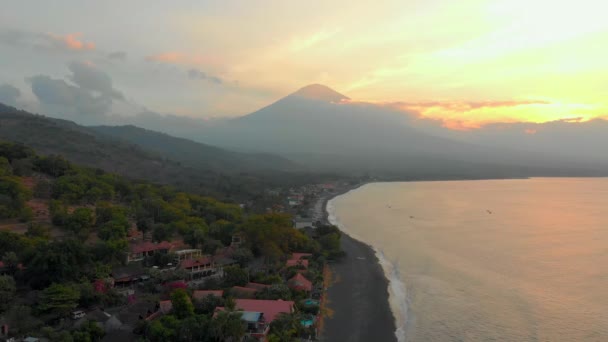 Foto aérea de la hermosa bahía de Jemeluk en el área de Amed con la vista sobre un maravilloso volcán Agung. Puesta de sol en Amed. Viajes al concepto de Bali — Vídeo de stock