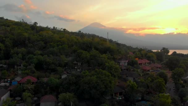 Foto udara dari teluk Jemeluk yang indah di daerah Amed dengan pemandangan gunung berapi Agung yang mengagumkan. Matahari terbenam di Amed. Perjalanan ke Bali konsep — Stok Video
