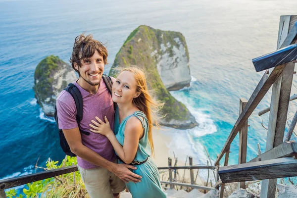 家庭度假生活方式。 幸福的男女夫妻站在不同的立场上. 看看高高的悬崖下美丽的海滩。 巴厘岛的旅游目的地。 努沙佩尼达岛上最受欢迎的旅游胜地 — 图库照片