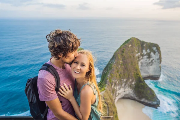 Estilo de vida familiar. O par feliz - homem e mulher estão no ponto de vista. Olhe para a bela praia debaixo do penhasco alto. Destino de viagem em Bali. Lugar popular para visitar na ilha de Nusa Penida — Fotografia de Stock