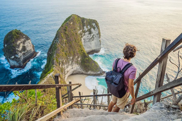 Family vacation lifestyle. Happy man stand at viewpoint. Look at beautiful beach under high cliff. Travel destination in Bali. Popular place to visit on Nusa Penida island — Stock Photo, Image